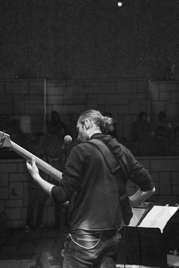 Ascoltare DC Notte: un'esperienza indimenticabile A black and white photo capturing a musician playing guitar during a concert.