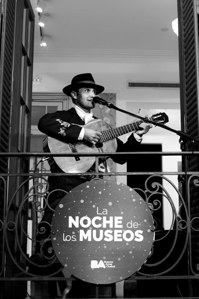DC Notte: un programma per nottambuli moderni Black and white photo of a guitarist singing at La Noche de los Museos event in Buenos Aires.