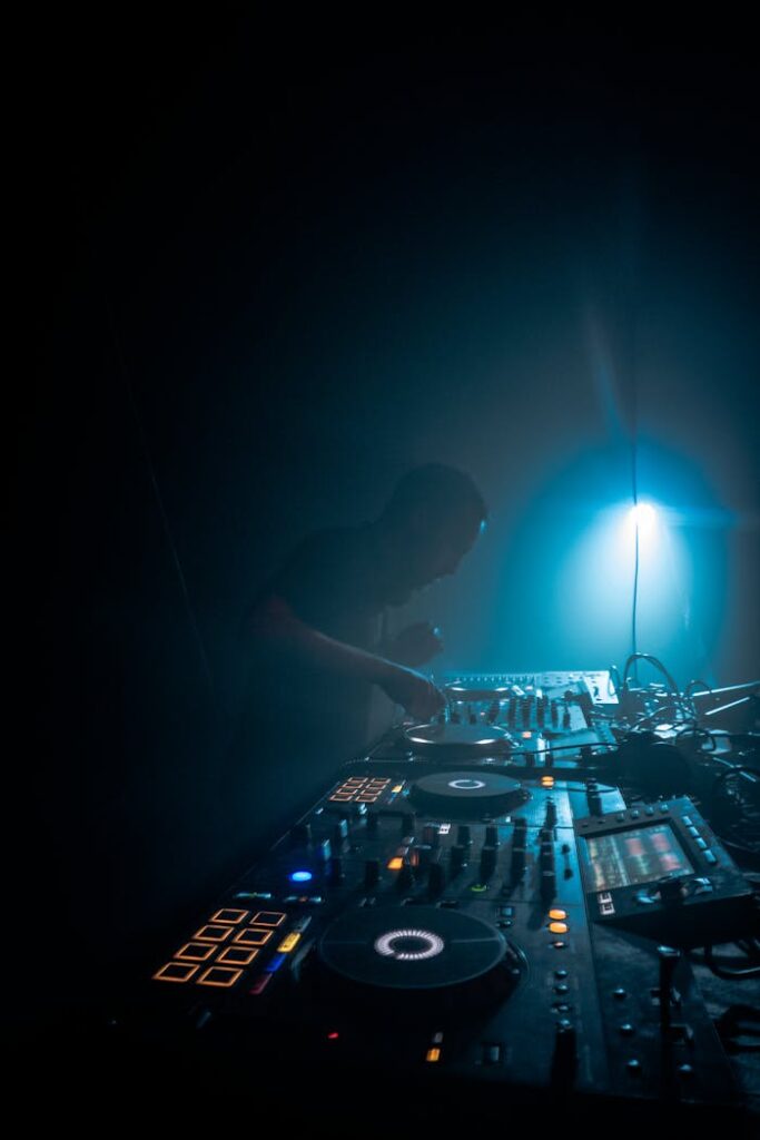 DJ mixing music on a sophisticated audio mixer in a dimly lit room.